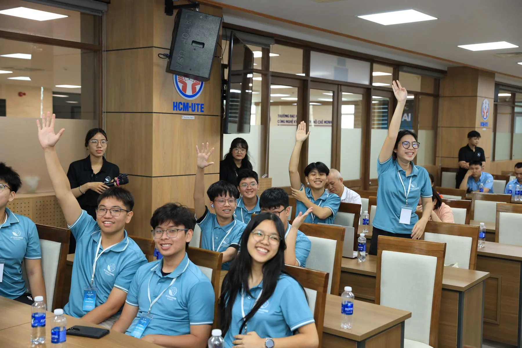 Students raising their hands during the EcoGen AI Challenge final