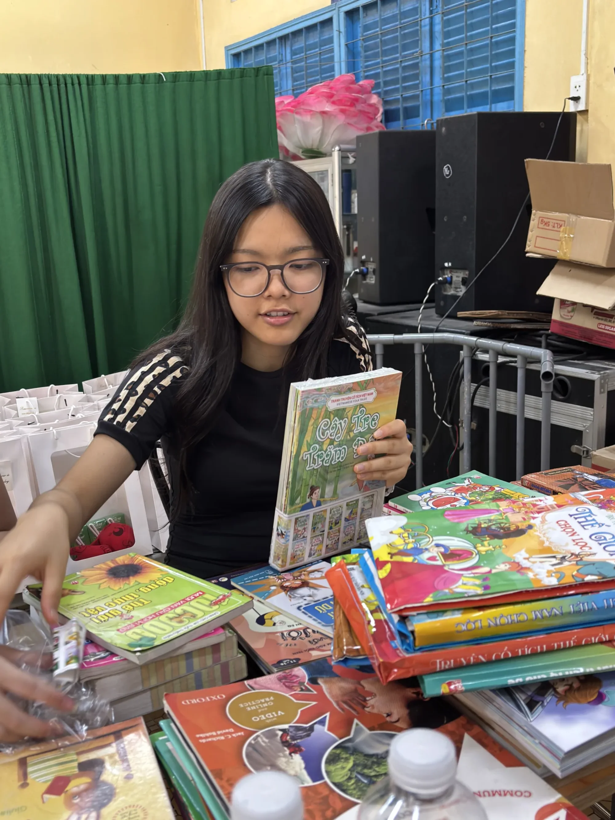 Ngân holding a book during Green Library preparation
