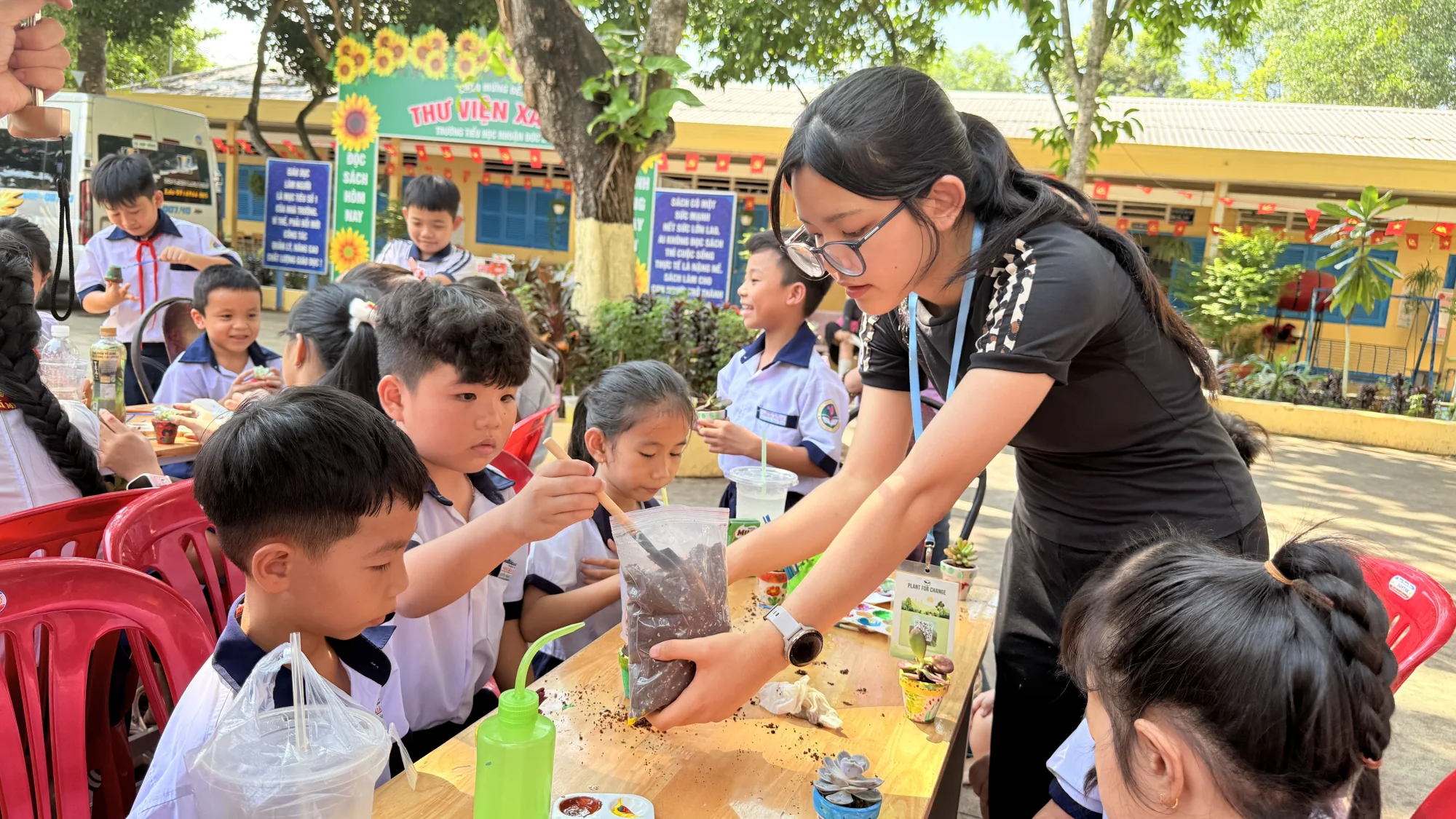 Ngân guiding children during a planting workshop