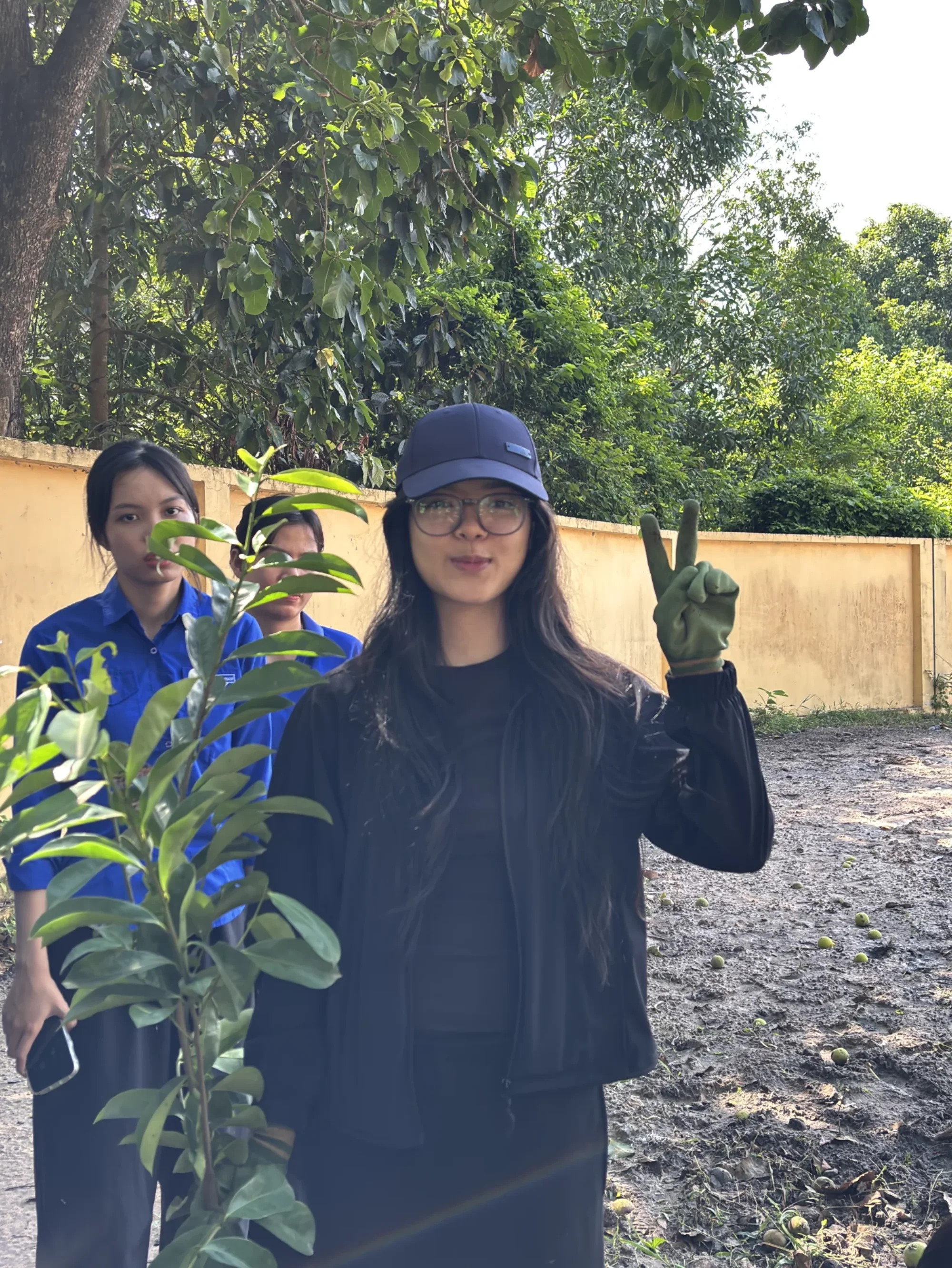 Plant For Change volunteers presenting a young tree before planting