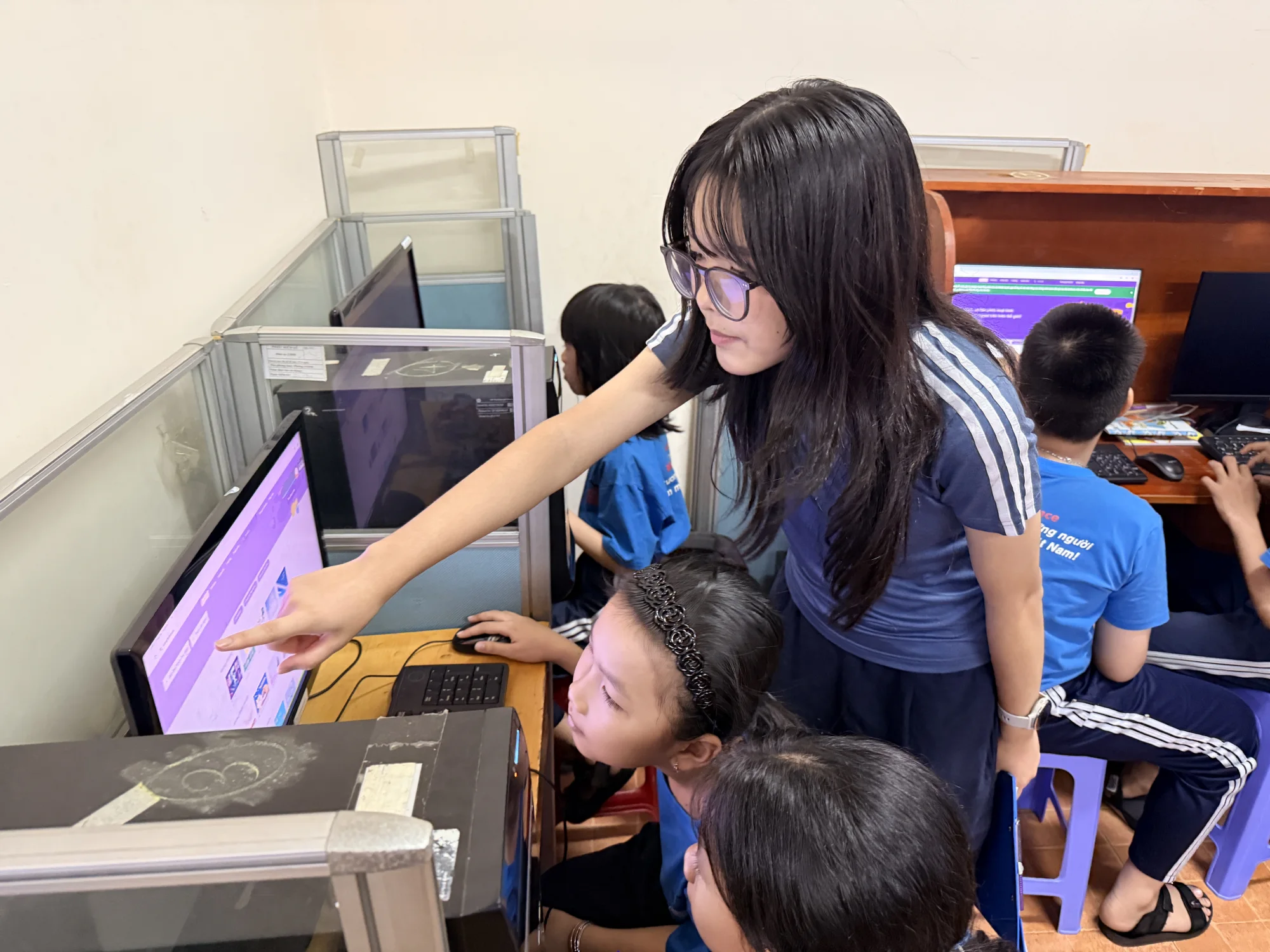 Ngân guiding students through a computer activity at Maison Chance
