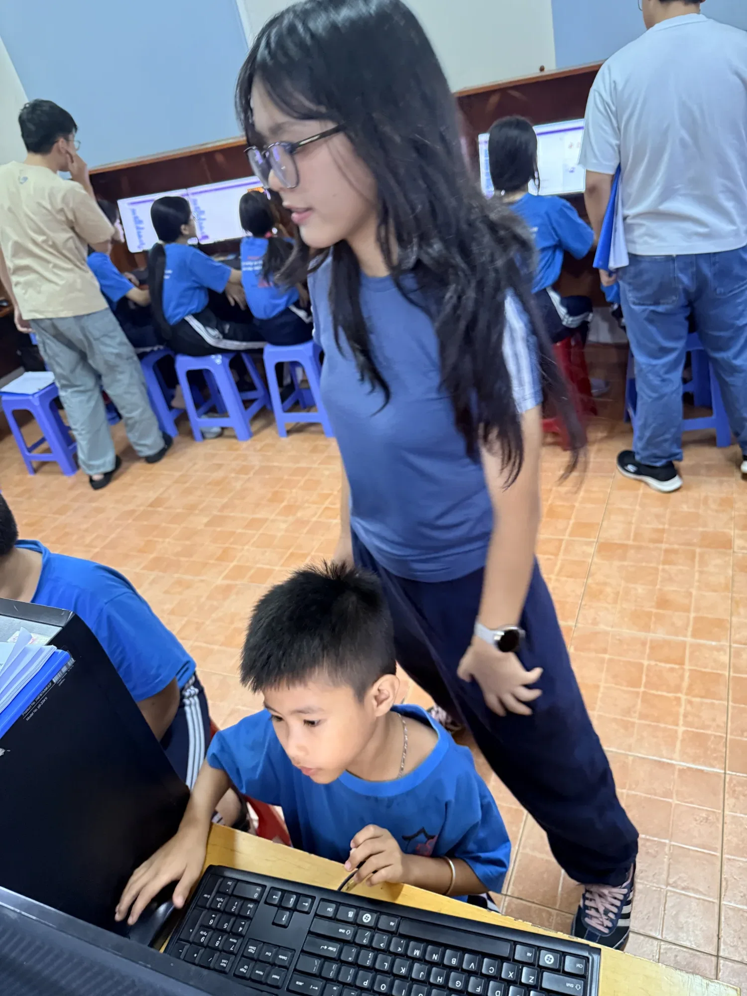Ngân supporting students in the computer classroom