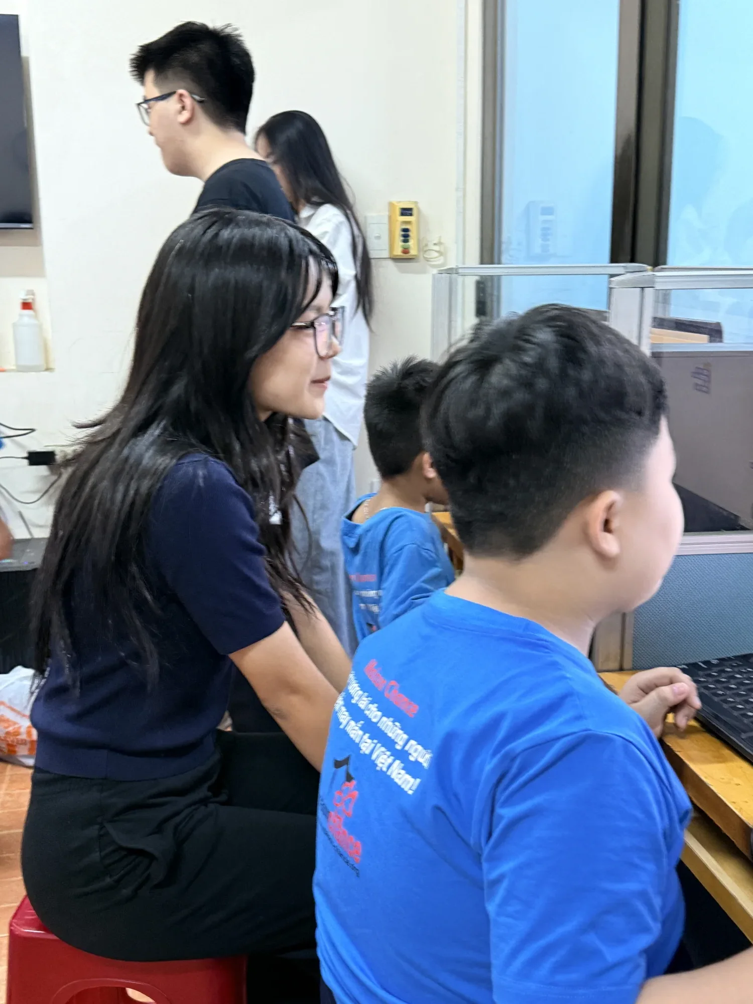 Ngân working alongside students at their computers