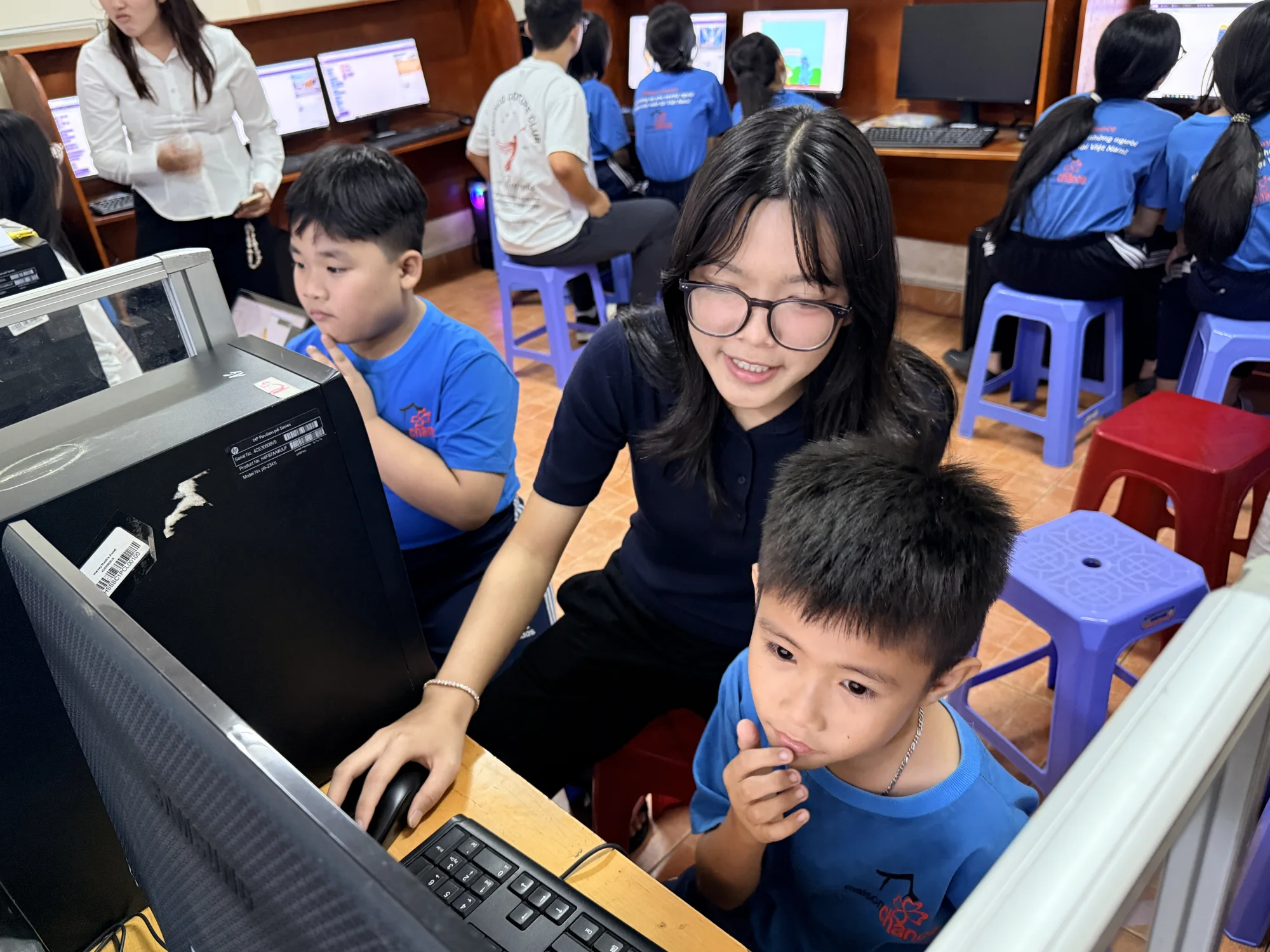 Ngân helping a student complete a computer activity