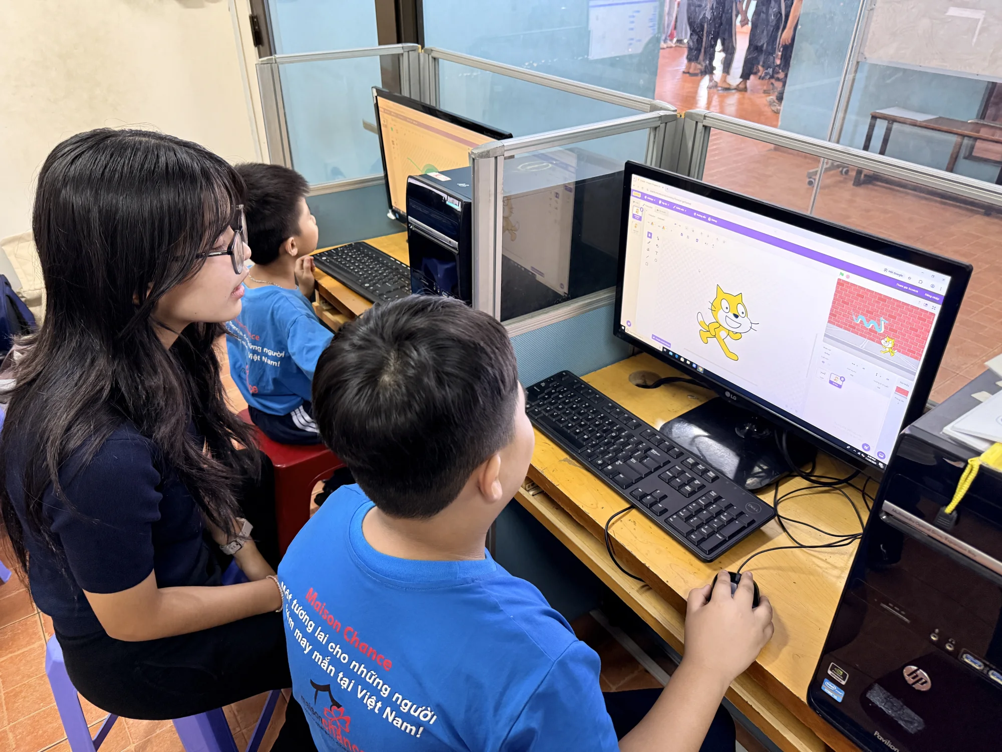 A student practicing Scratch programming alongside Ngân
